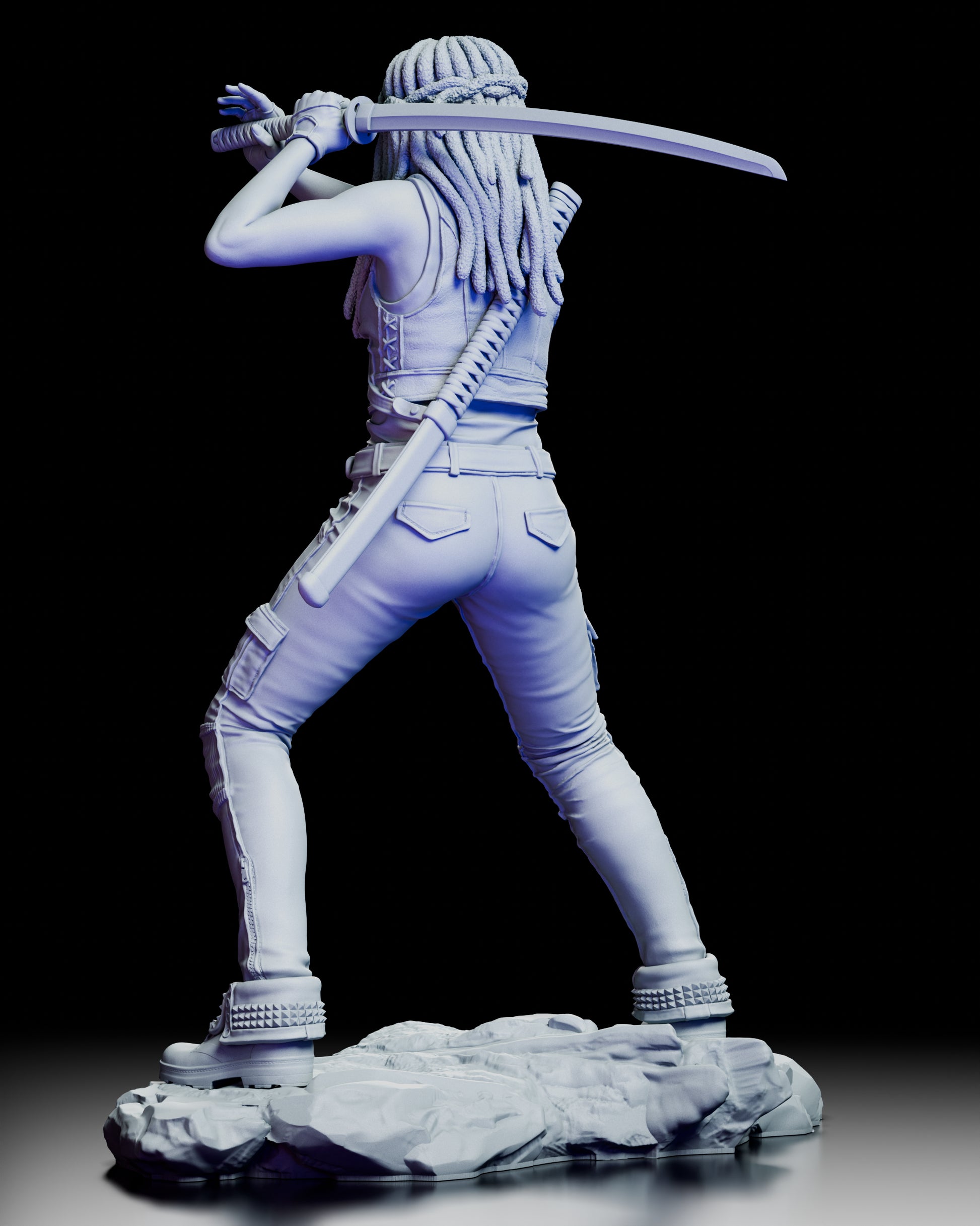Rear view of the Michonne figure kit showing her raised katana stance, detailed braided hair, and textured clothing on a rocky base.